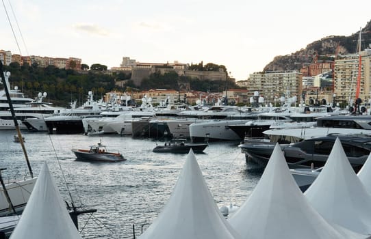 Monaco, Monte Carlo, 29 September 2022 - a lot of luxury yachts at the famous motorboat exhibition at sunset, the most expensive boats for the richest people, yacht brokers, boat traffic. High quality photo