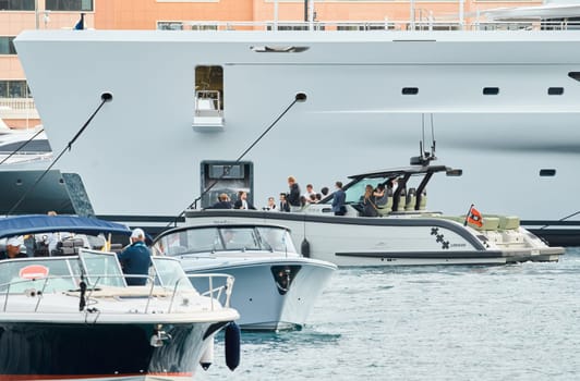 Monaco, Monte Carlo, 29 September 2022 - Water taxi by luxury motorboat on the famous yacht exhibition, a lot of most expensive luxury yachts, richest people, yacht brokers, boat traffic. High quality photo