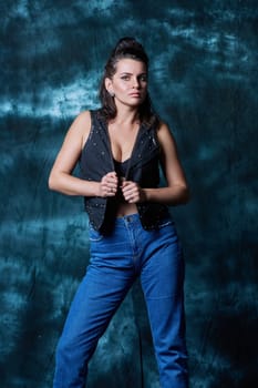 Young trendy woman posing in the studio in denim style. Fashion, style, clothing, trends concept
