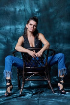 Young trendy woman posing in the studio in denim style. Fashion, style, clothing, trends concept