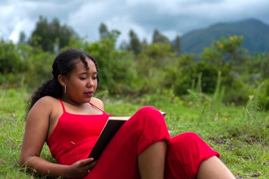 young latin girl lying in the field with a book on her legs reading in a relaxation exercise. book day. High quality photo