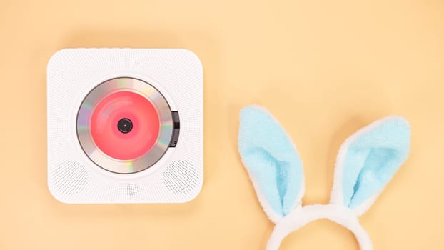 White cd player with red disc with bunny ears on yellow background. Love music, Easter bunny, retro Love song, space for text