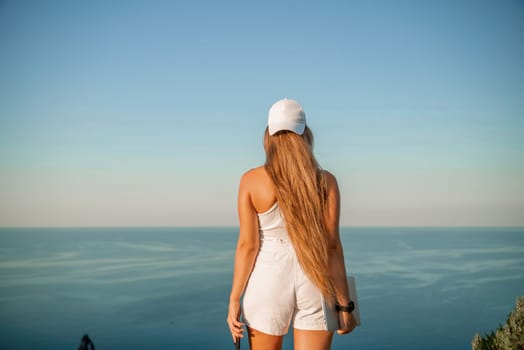 Portrait of a happy woman in a cap with long hair against the sea.