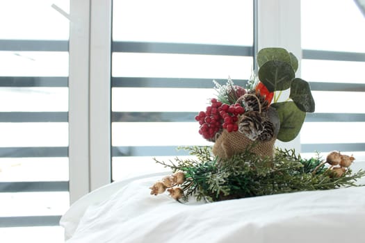 decorative composition on a snow-white bed against the background of a window overlooking a mountainous landscape in winter. High quality photo