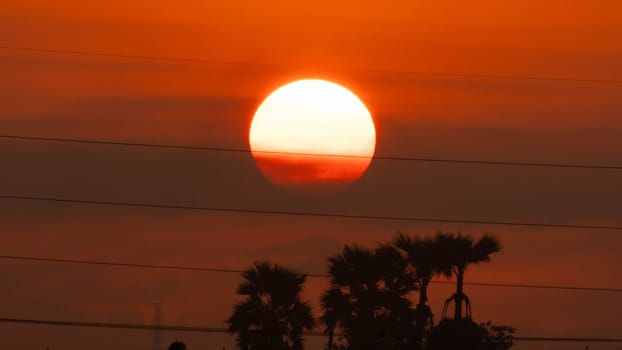 Beautiful nature morning with orange, yellow sunshine and fluffy clouds. Time lapse of a beautiful dramatic sky with a big sun at sunrise.