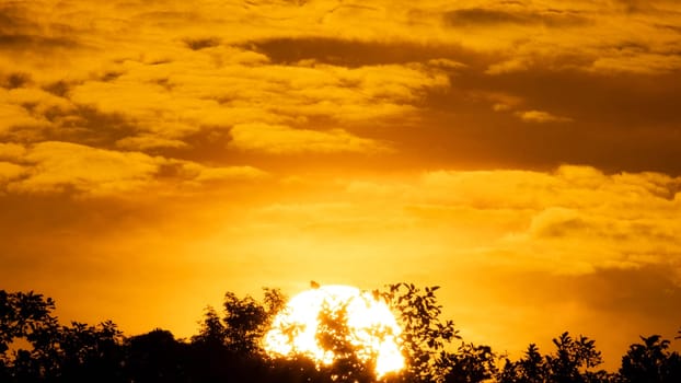 Beautiful nature morning with orange, yellow sunshine and fluffy clouds. Beautiful colorful dramatic sky with clouds at sunset or sunrise.