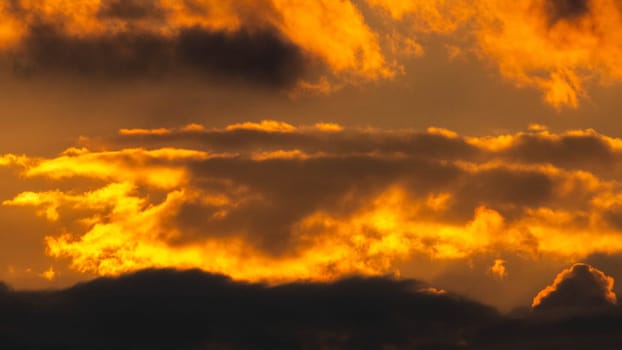 Beautiful nature morning with orange, yellow sunshine and fluffy clouds. Beautiful colorful dramatic sky with clouds at sunset or sunrise.