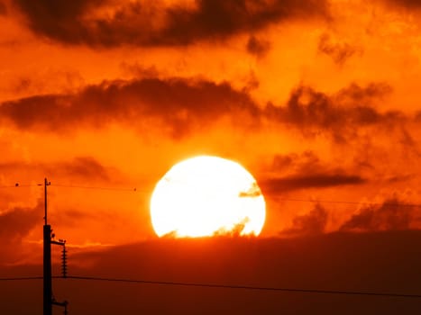 Beautiful nature morning with orange, yellow sunshine and fluffy clouds. Time lapse of a beautiful dramatic sky with a big sun at sunrise.