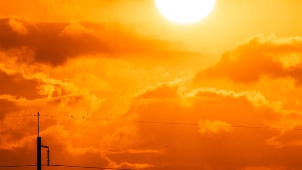 Beautiful nature morning with orange, yellow sunshine and fluffy clouds. Time lapse of a beautiful dramatic sky with a big sun at sunrise.