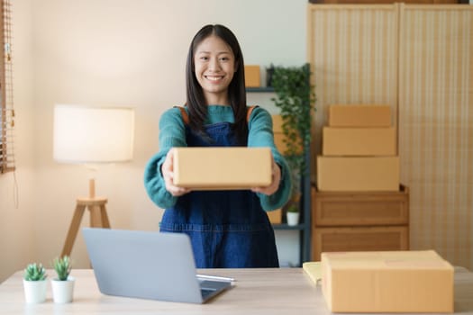 Asian female business owner handles delivery of orders to customers.