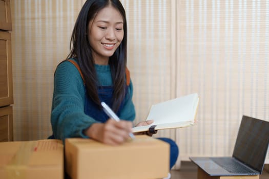 Asian female business owner handles delivery of orders to customers.