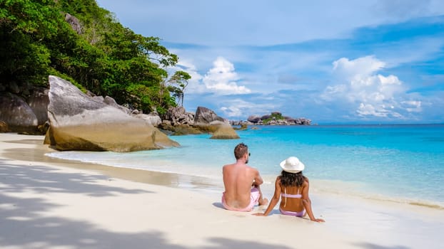 A couple of Asian women and white men relaxing on the beach at the Similan Islands in Thailand Phannga. couple visit the Similan Islands on a boat trip during vacation