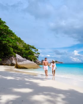 A couple of women and men relaxing on the beach in the sun at the Similan Islands in Thailand Phannga. couple visit the Similan Islands on a boat trip during vacation