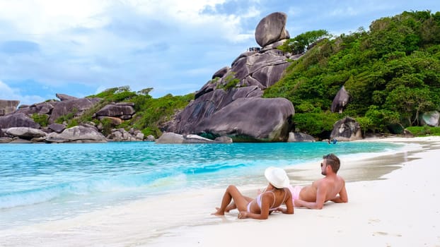 A couple of Asian women and white men relaxing on the beach at the Similan Islands in Thailand Phannga. couple visit the Similan Islands on a boat trip during vacation