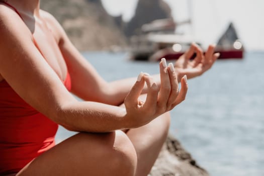 Woman sea yoga. Back view of free calm happy satisfied woman with long hair standing on top rock with yoga position against of sky by the sea. Healthy lifestyle outdoors in nature, fitness concept.