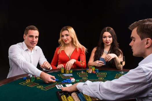 Happy people and dealer playing blackjack. Poker. Luxury women in dresses