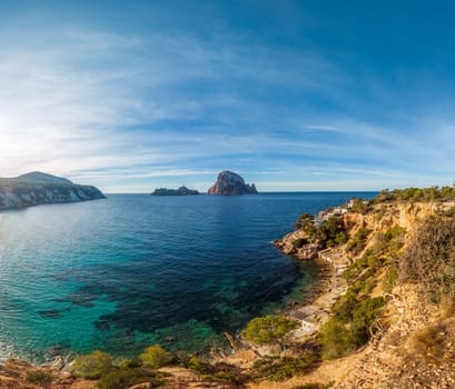 Tranquil Mediterranean coast with a panoramic seascape, clear waters, and rocky islets.