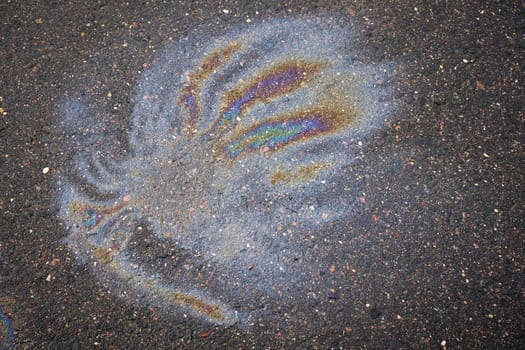 Fuel or oil stain on an asphalt road as a texture or background.