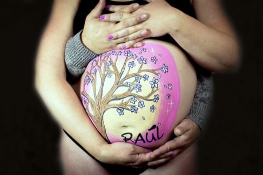 Family scene with pregnant mother and father hugging. No copy space