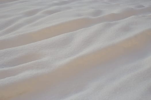 Photo abstract background of white snow drifts taken in the afternoon.