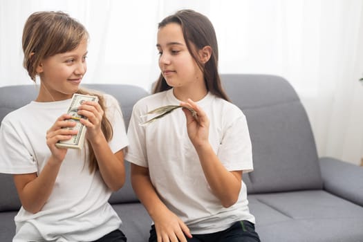 Photo of lucky caucasian girls wearing casual clothing holding fans of dollars in hands. High quality photo