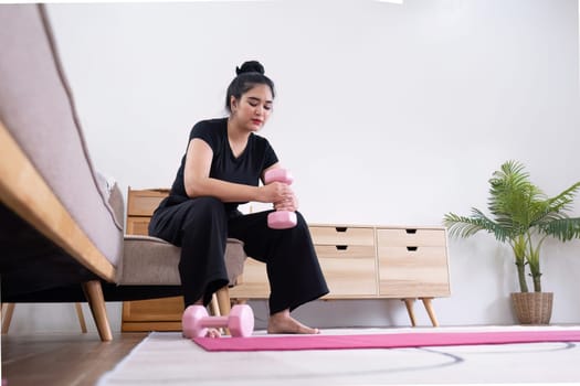 Fat woman exercising at home A beautiful oversized woman in a sports bra and casual pants sits in the living room