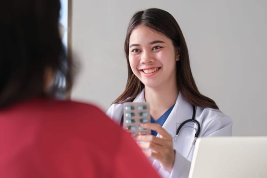 An Asian female doctor is consulting a patient who comes to discuss taking medication for health care. and treat disease with medicine.