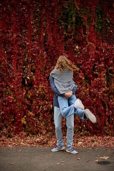 Young Cute Female Hugs Boyfriend. In Autumn Outdoor. Lovers Walking in Park. Attractive Funny Couple. Lovestory in Forest. Man and Woman. Cute Lovers in the Park. Family Concept. Happy Couple.