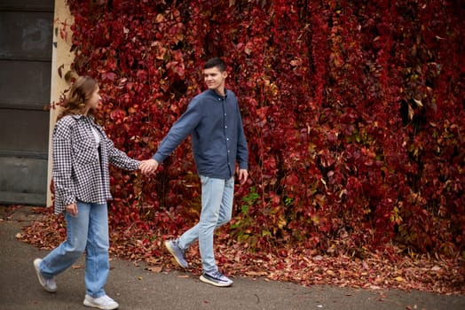 Young Cute Female Hugs Boyfriend. In Autumn Outdoor. Lovers Walking in Park. Attractive Funny Couple. Lovestory in Forest. Man and Woman. Cute Lovers in the Park. Family Concept. Happy Couple.