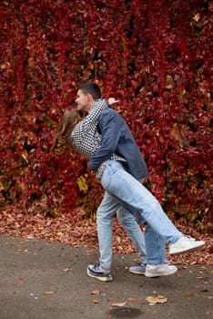 Young Cute Female Hugs Boyfriend. In Autumn Outdoor. Lovers Walking in Park. Attractive Funny Couple. Lovestory in Forest. Man and Woman. Cute Lovers in the Park. Family Concept. Happy Couple.