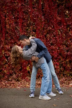 Young Cute Female Hugs Boyfriend. In Autumn Outdoor. Lovers Walking in Park. Attractive Funny Couple. Lovestory in Forest. Man and Woman. Cute Lovers in the Park. Family Concept. Happy Couple.