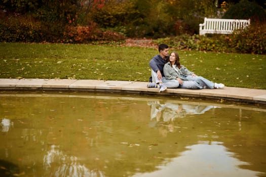 lovely young couple kissing outdoors in autumn. Loving couple walking in nature. Autumn mood. Happy man and woman hugging and kissing in autumn. Love. Fashionable couple outdoors. Fashion, people and lifestyle. Stylish couple in autumn outfit.