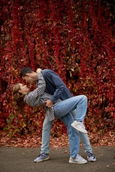 Young Cute Female Hugs Boyfriend. In Autumn Outdoor. Lovers Walking in Park. Attractive Funny Couple. Lovestory in Forest. Man and Woman. Cute Lovers in the Park. Family Concept. Happy Couple.