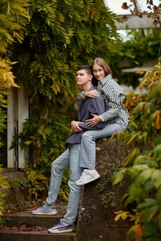 Young Cute Female Hugs Boyfriend. In Autumn Outdoor. Lovers Walking in Park. Attractive Funny Couple. Lovestory in Forest. Man and Woman. Cute Lovers in the Park. Family Concept. Happy Couple.