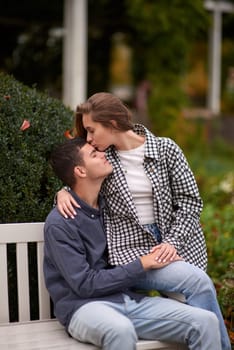 lovely young couple kissing outdoors in autumn. Loving couple walking in nature. Autumn mood. Happy man and woman hugging and kissing in autumn. Love. Fashionable couple outdoors. Fashion, people and lifestyle. Stylish couple in autumn outfit.
