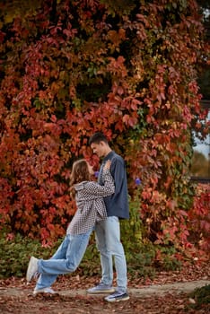 Young Cute Female Hugs Boyfriend. In Autumn Outdoor. Lovers Walking in Park. Attractive Funny Couple. Lovestory in Forest. Man and Woman. Cute Lovers in the Park. Family Concept. Happy Couple.