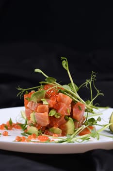 Avocado tartare with salmon, red caviar and pea sprouts.