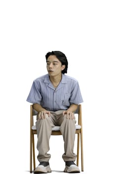 A guy in a blue shirt, on a white background, is sitting on a chair.
