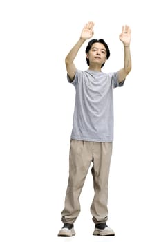 A guy in a gray T-shirt, on a white background, in full height, raised his hands up.