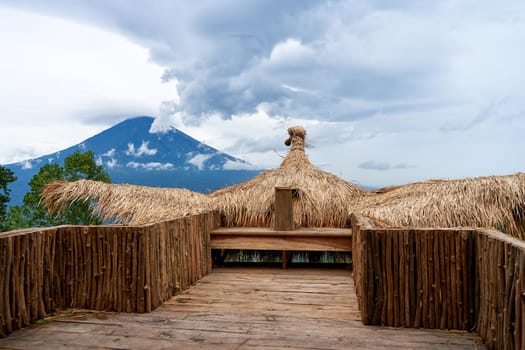 A large straw photo zone - a bird on a viewpoint overlooking the sacred volcano Agung, hidden by clouds on a rainy day on the island of Bali