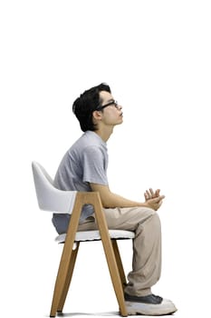 A guy in a gray T-shirt, on a white background, is sitting on a chair.