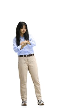 A girl in a blue shirt, on a white background, in full height, looks at the clock.