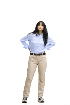 A girl in a blue shirt, on a white background, full-length, hands on her belt.