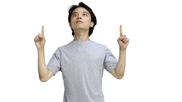 Guy in a gray T-shirt, on a white background, close-up, pointing up.