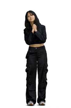 A woman in black clothes, on a white background, in full height, is touched.