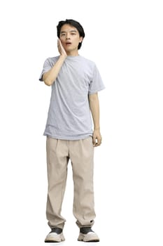 A guy in a gray T-shirt, on a white background, in full height, yawns.