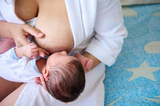 Close-up of a caring loving mother breastfeeding her newborn baby. The importance of breastfeeding for the baby's immune system and prophylaxis of breast cancer. Lactation. Motherhood lifestyle