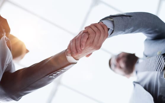 Business partners shaking hands in meeting hall