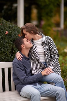 lovely young couple kissing outdoors in autumn. Loving couple walking in nature. Autumn mood. Happy man and woman hugging and kissing in autumn. Love. Fashionable couple outdoors. Fashion, people and lifestyle. Stylish couple in autumn outfit.