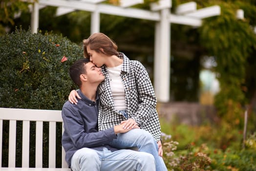 lovely young couple kissing outdoors in autumn. Loving couple walking in nature. Autumn mood. Happy man and woman hugging and kissing in autumn. Love. Fashionable couple outdoors. Fashion, people and lifestyle. Stylish couple in autumn outfit.